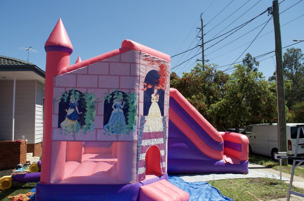 Side of pink Disney Princess jumping castle with slide