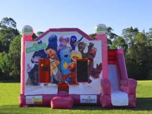 Pink Sesame Street jumping castle with slide