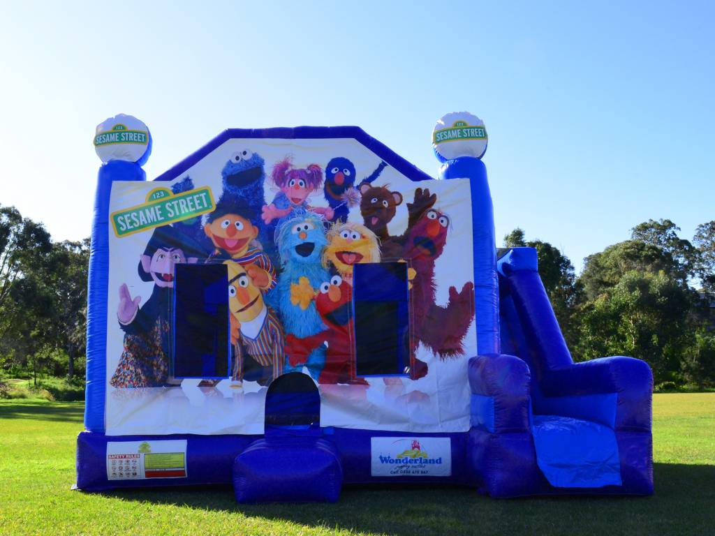 Blue Sesame Street jumping castle with slide